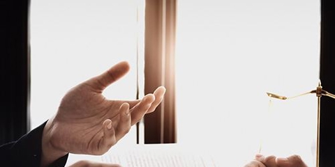 image of two people talking at a desk that has a gavel on it